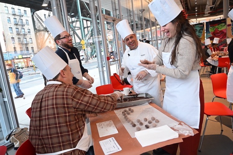 Chef Mike helps people make truffles at a table at The Forum.