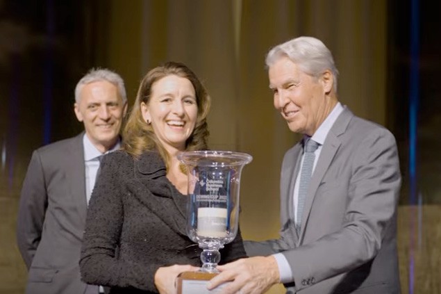 A person receiving a large cup trophy at the Deming Cup event.