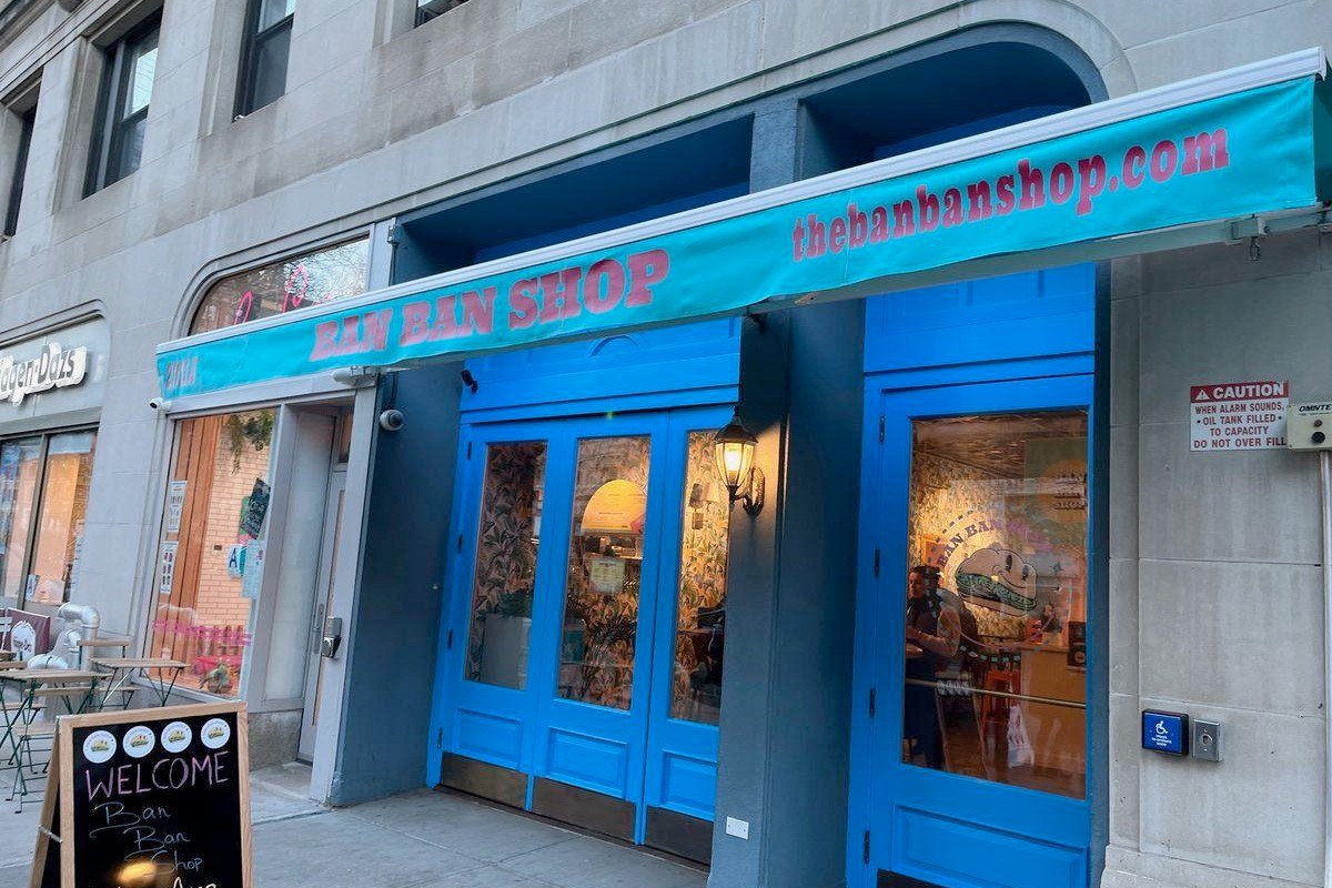 A view of the storefront of Ban Ban Shop, which has a bright blue facade and awning.