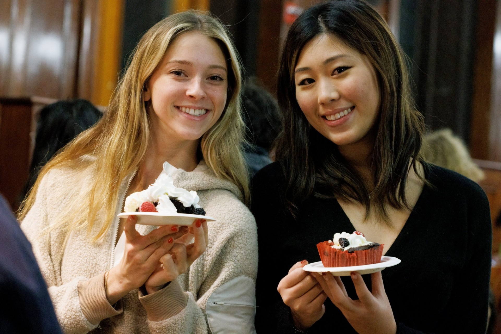 Two students hold up desserts in John Jay Dining Hall.
