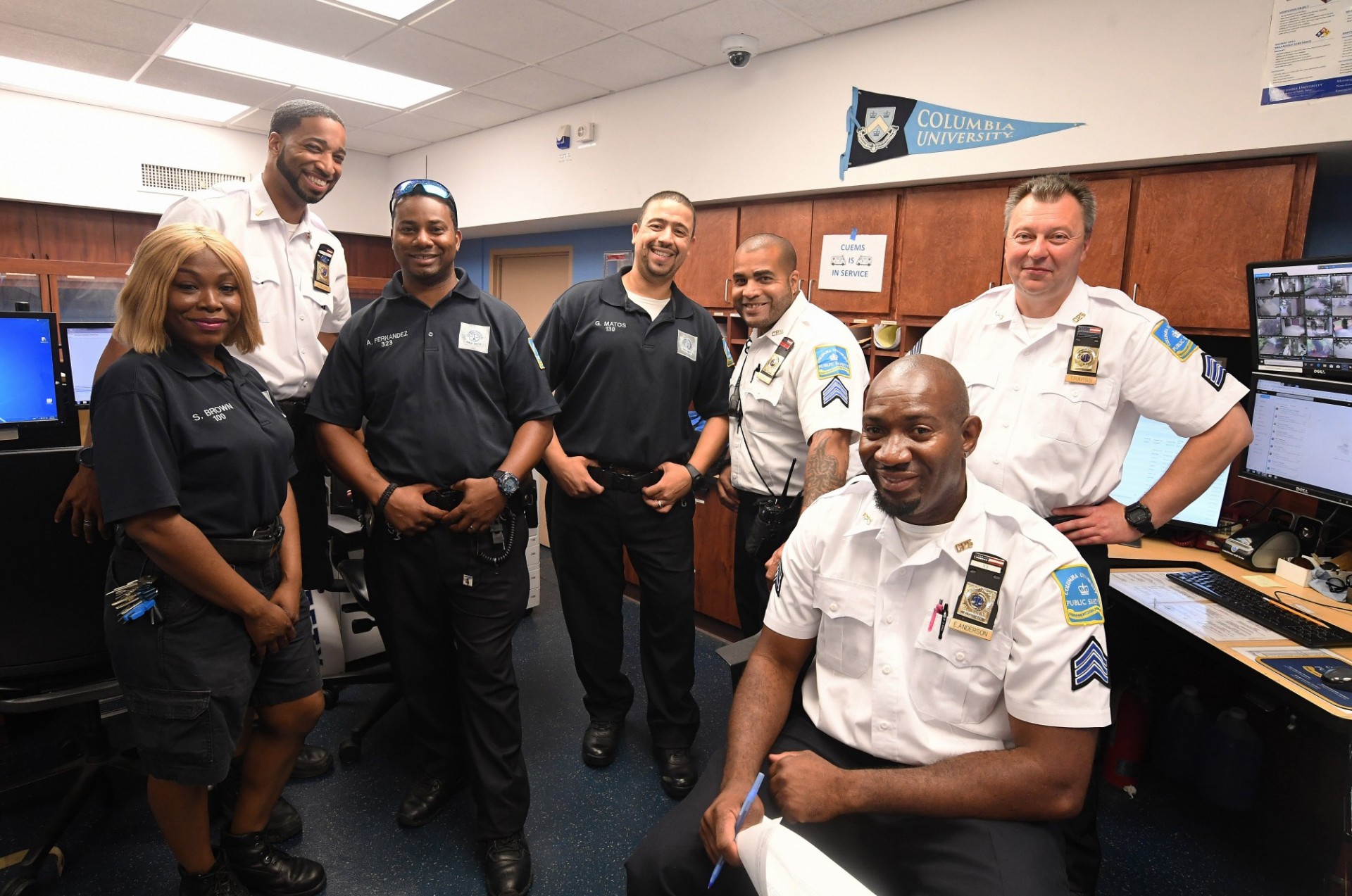 A group of Public Safety officers stand together inside an office.