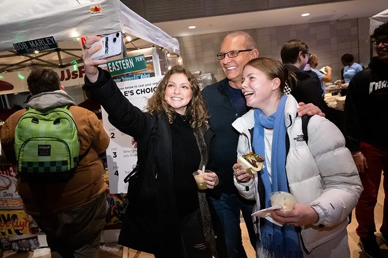 Two students take a picture with Chef Robert Irvine at Battle of the Dining Halls
