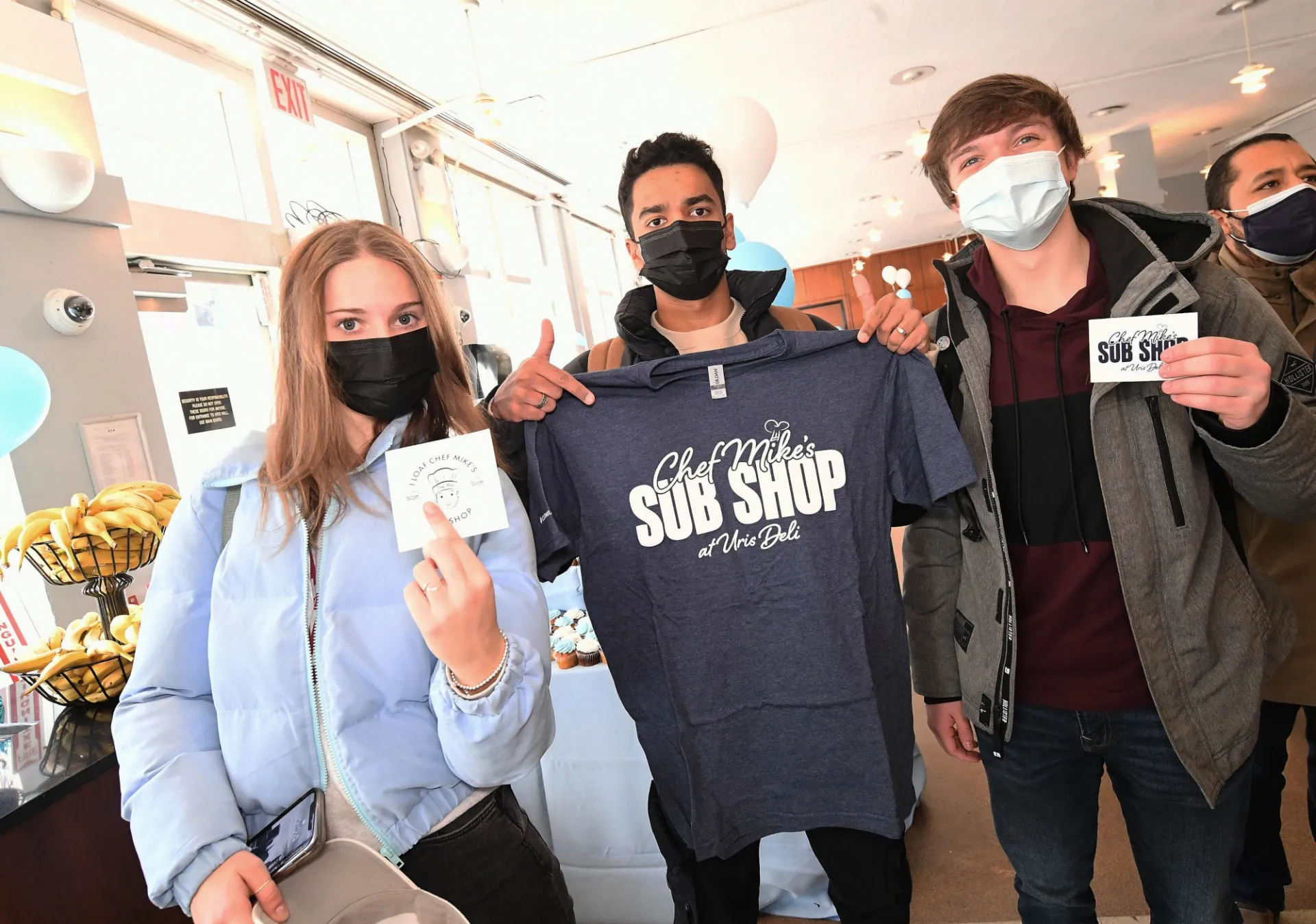 Students hold up Chef Mike's Sub Shop swag at the Grand Opening event